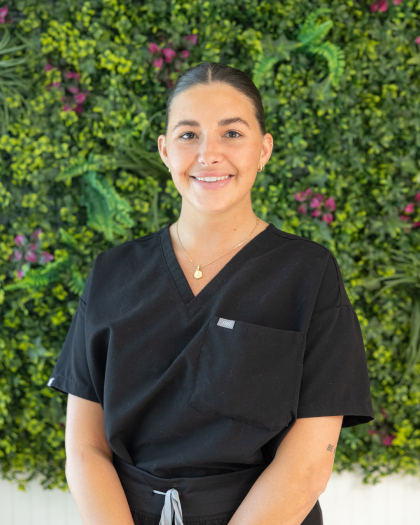 Candes R., dental team member, smiling in professional black scrubs at Gregory Building in Pompano Beach.