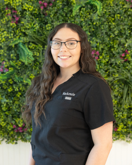 Mackenzie, a dental team member at Pompano Beach practice, smiles in professional portrait.