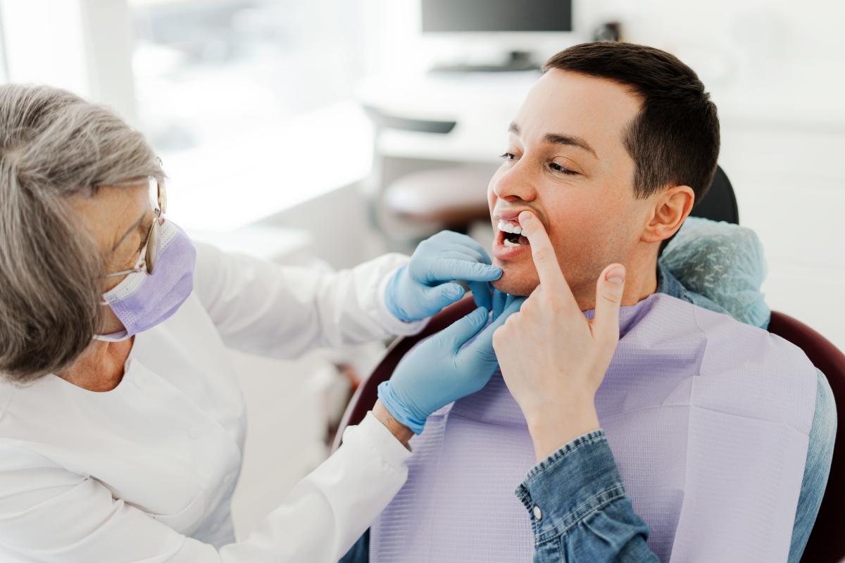 Dentist examining patient's mouth during orthodontic treatment consultation.
