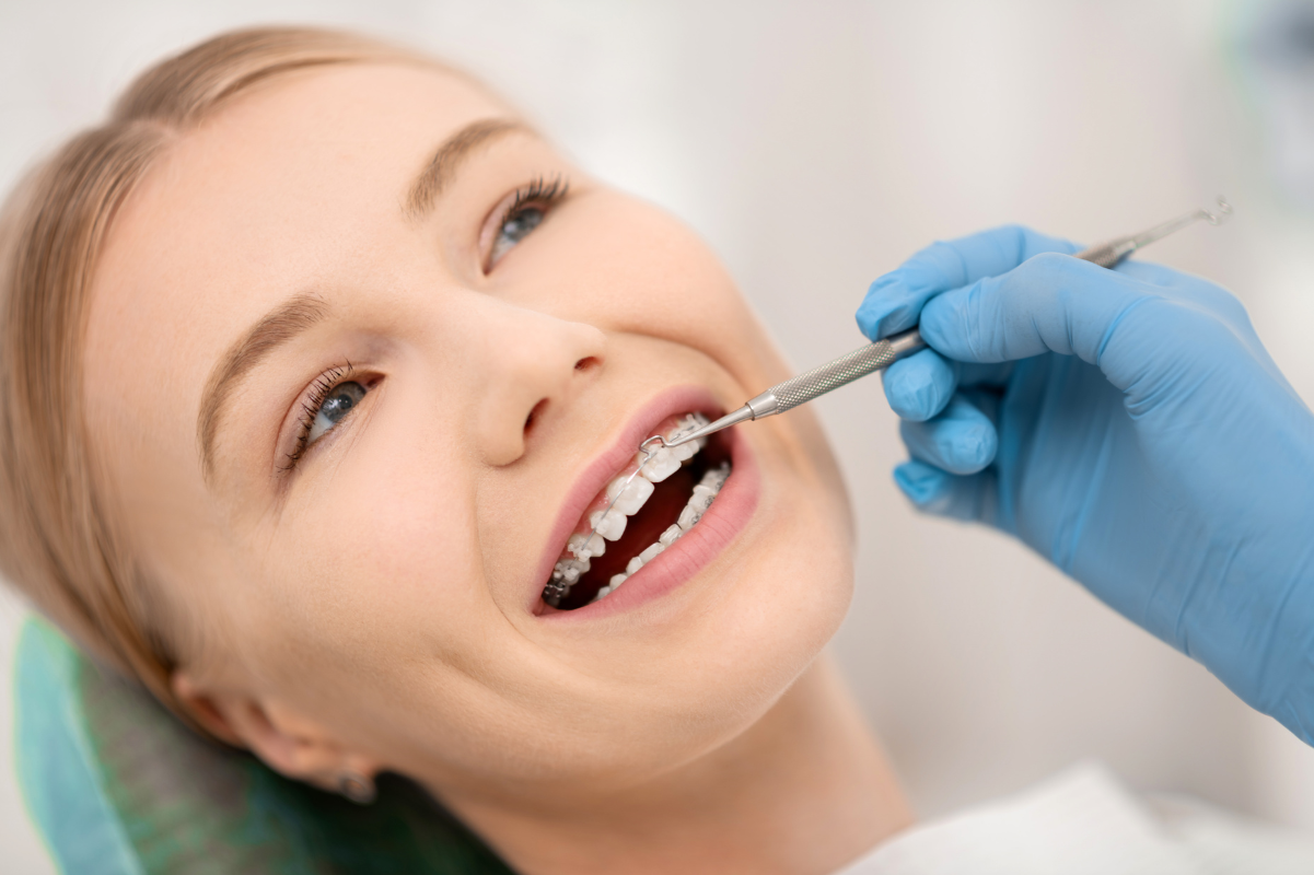 Dentist examining patient's teeth during orthodontic treatment evaluation.